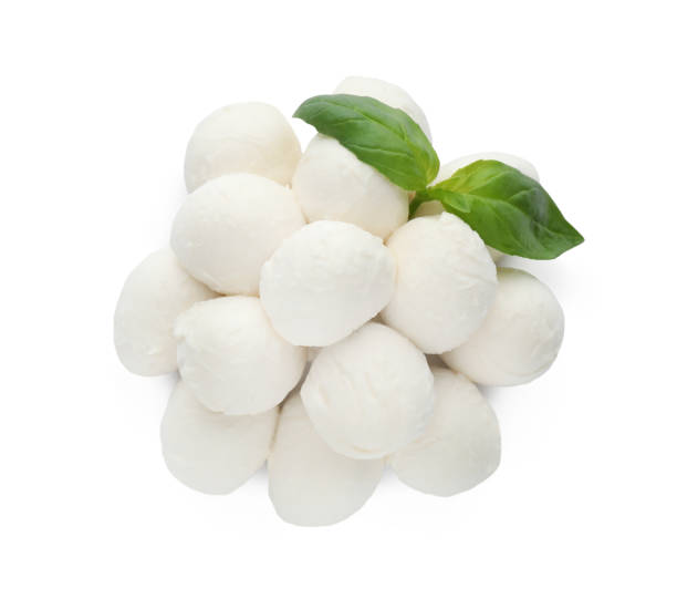 istock Pile of mozzarella cheese balls and basil on white background, top view 1425556827