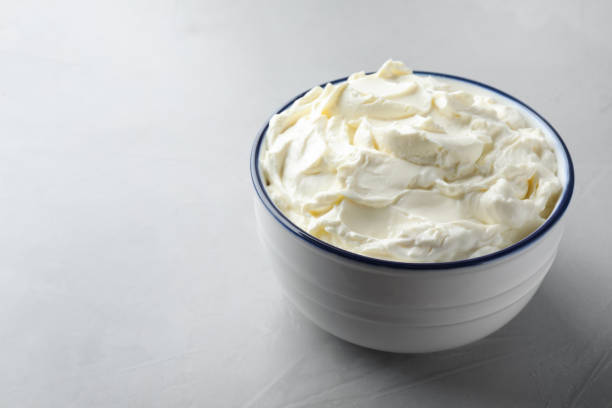 istock Bowl of tasty cream cheese on grey table. Space for text 1425556989