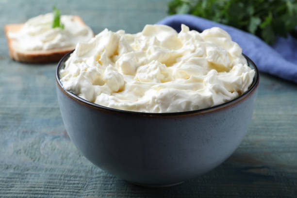 istock Tasty cream cheese on light blue wooden table, closeup 1425557554