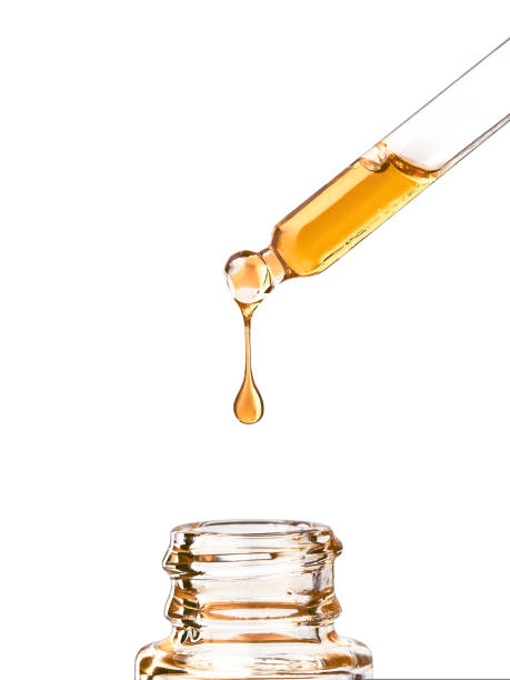 istock Cosmetic pipette with yellow oily drop on white bg 1425560035