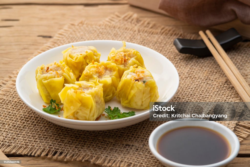 Shumai or Chinese Steamed Dumpling,meatball dumpling with wanton skin in with plate Shumai or Chinese Steamed Dumpling,meatball dumpling with wanton skin in with plate,served with soy sauce Appetizer Stock Photo