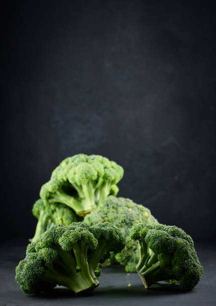 istock Fresh green head of broccoli on black background 1425560534