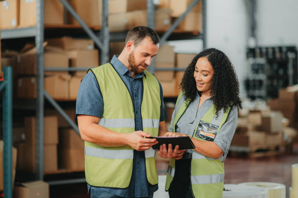 istock Supply chain, shipping and logistics colleagues with a tablet planning delivery schedule in a warehouse. b2b, teamwork and partnership in a box, cargo and courier service workplace sharing work idea 1425560599