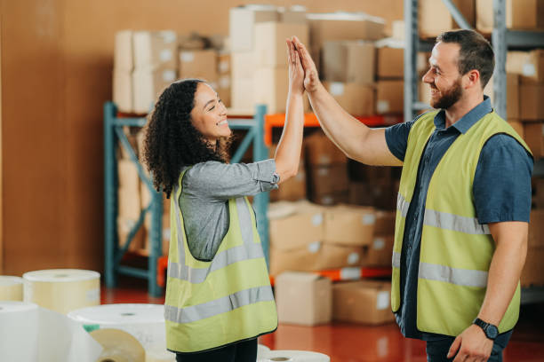istock High five, cargo warehouse and teamwork with colleagues at ecommerce products delivery plant. Team building, collaboration and support in the stock distribution industry with helpful coworkers. 1425560613