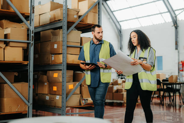 istock Shipping, ecommerce and retail stock warehouse workers planning a shipment box layout strategy. Freight courier, e commerce and supply chain export team walking and working on delivery logistics 1425560616