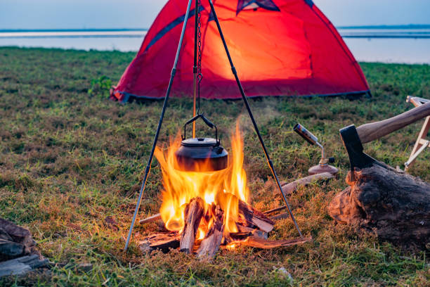 istock Camping bonfire on the grass by the lake at sunset 1425562998