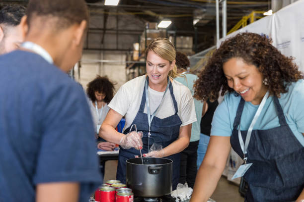 grupo de voluntarios multirraciales prepara comidas para el comedor de beneficencia - homelessness men white black fotografías e imágenes de stock