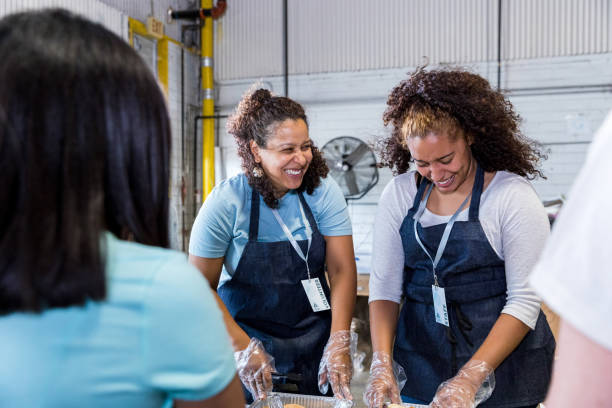 istock Mother smiles at daughter while serving food at event 1425563089