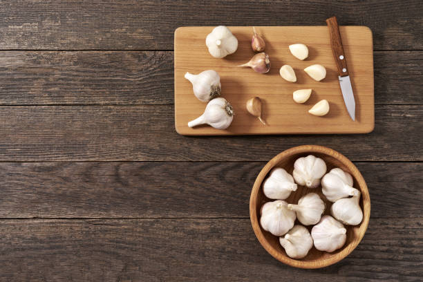 istock Garlic cloves and bulbs on a cutting board, top view. 1425565233
