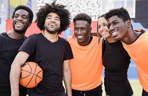 Personas multiétnicas abrazándose después de un partido de baloncesto al aire libre photo