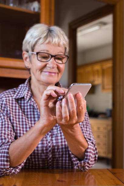 istock Senior woman using phone, making video call 1425567964