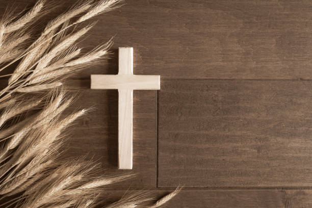 istock Cross and wheat border on dark wood 1425569016