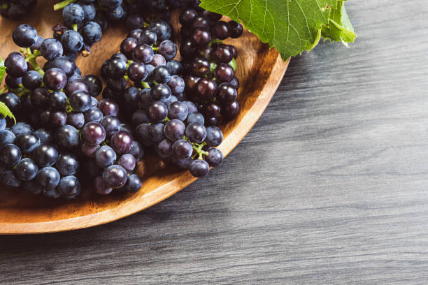 istock Ripe grapes on teak tray on dark wood table 1425569164