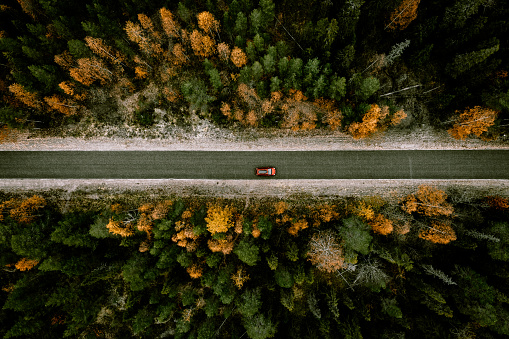 Aerial view of fall road with autumn woods and first snow in Finland, Lapland