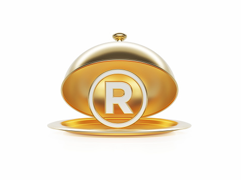 Register symbol sitting inside of a gold platter sitting on white background. Horizontal composition with copy space.
