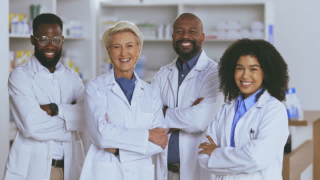 Portrait of a group of pharmacists working in a pharmacy of medicine, medicare and healthcare. Happy team of pharmaceutical workers standing in a medical wellness clinic with a medication dispensary.