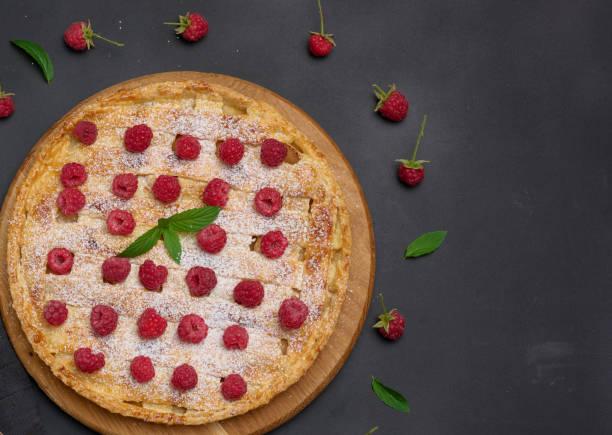 istock Round baked pie with apples and sprinkled with powdered sugar on a black table. 1425571753