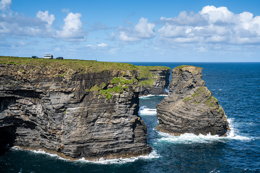 Kilkee, Ireland - 4 August, 2022: tourists enjoy a visit to the Kilkee Cliffs with vehicles parked close to the edge
