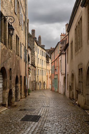 Dole, France - 14 September, 2022: deserted city streets in the center of Dole with historic art nouveau buildings and cobblestone street under an overcast sky