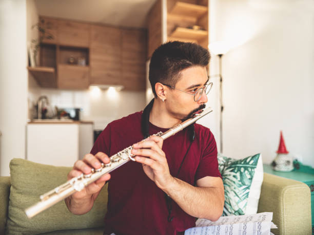 istock Young male musician practising flute at home 1425576970