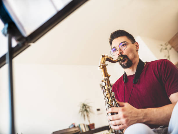 istock Young male musician practising saxophone at home 1425577172