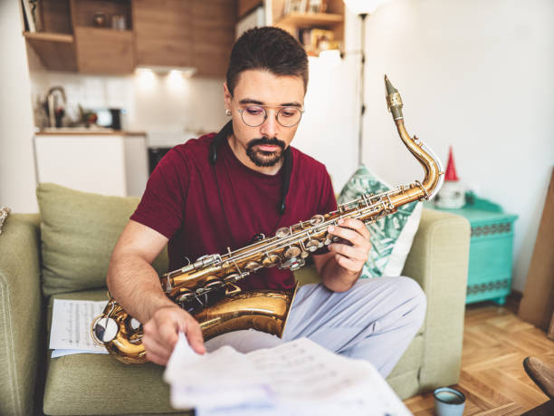 istock Young male musician practising saxophone at home 1425577492