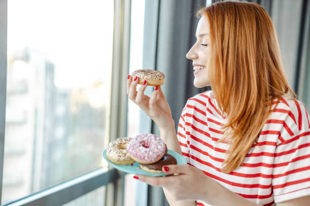 istock Young woman eating sweets at home 1425577995