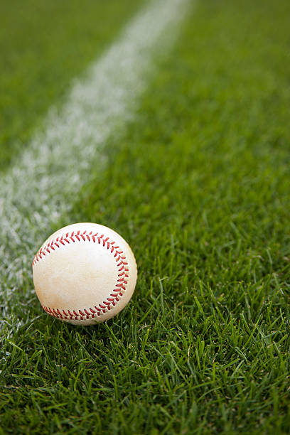 palla da baseball in un campo durante una partita di baseball - baseball field grass baseballs foto e immagini stock