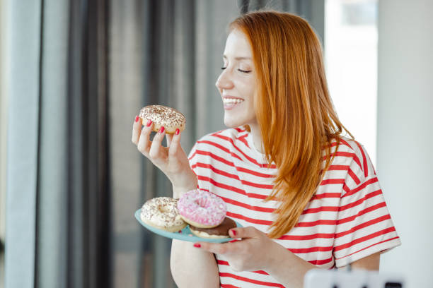 istock Young woman eating sweets at home 1425578389