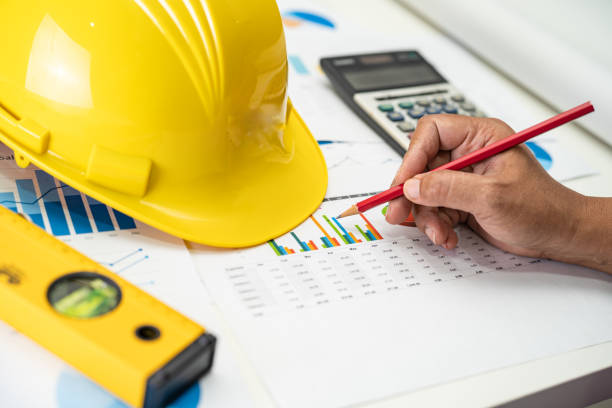 istock Asian engineer with plan project blueprint, graph and yellow helmet and engineering construction tools. 1425579382