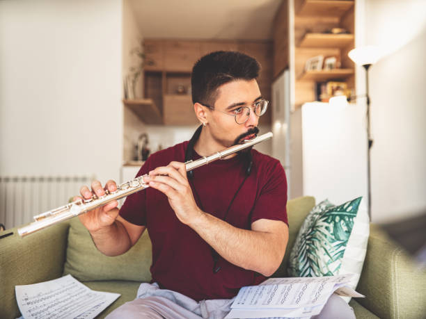 istock Young male musician practising flute at home 1425582249