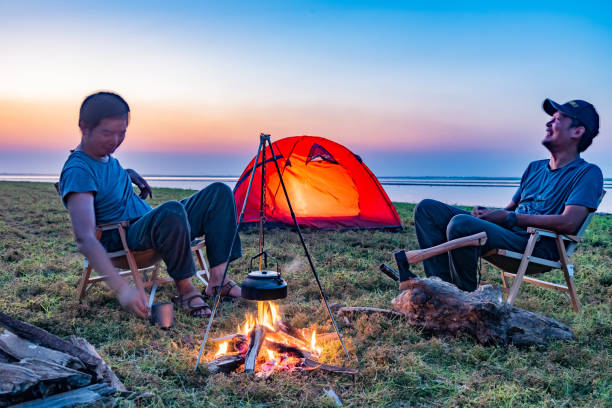 istock Two people camping by the lake with a bonfire 1425582769