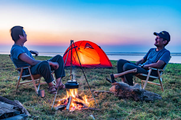istock Two people camping by the lake with a bonfire 1425582781