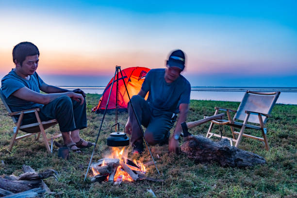 istock Two people camping by the lake with a bonfire 1425582893