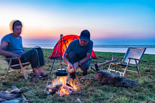 istock Two people camping by the lake with a bonfire 1425583115