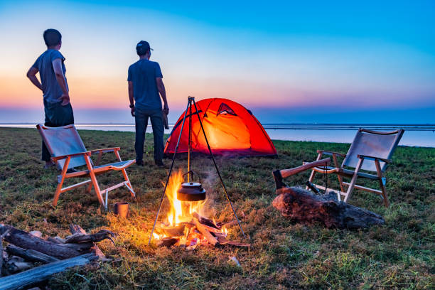 istock Two people camping by the lake with a bonfire 1425583353