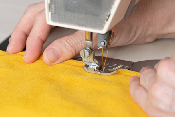 mains de couturière cousant avec une machine professionnelle. concept d’usine, maison - machine sewing white sewing item photos et images de collection