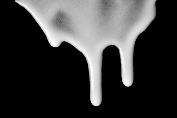 istock Streaks of white cream on a black background. 1425588072