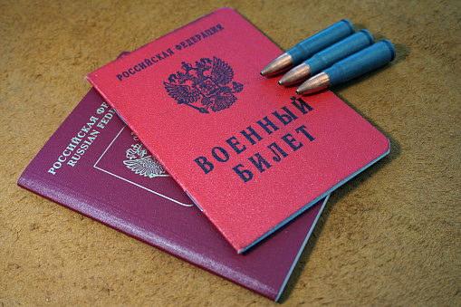 Russian military ID on top of Russian passport and three bullets in caliber 7.62x39mm. It symbolizes that people eligeable for draft may not be allowed to leave the country.