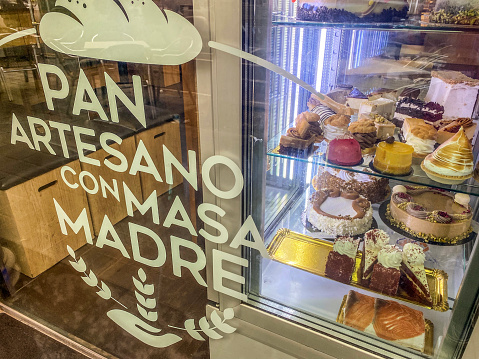 Valencia, Spain - April 27, 2022: Bakery store window with delicious cakes on displays. The city has plenty of  businesses selling sweet food as well as bars and restaurants