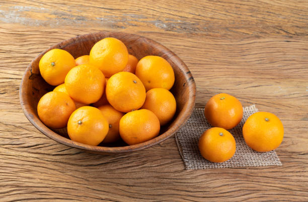 istock Mini tangerines in a bowl over wooden table 1425600002