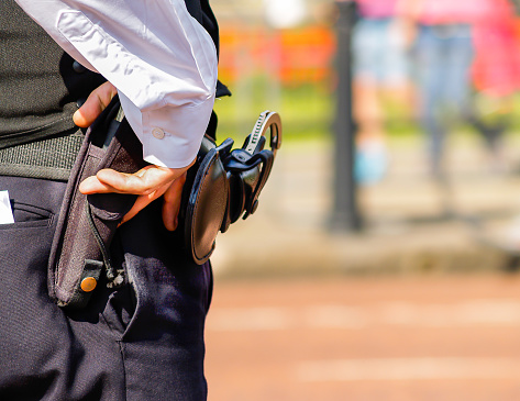 Policeman’s hand, holster and cuff links.closeup in selective focus on London street.