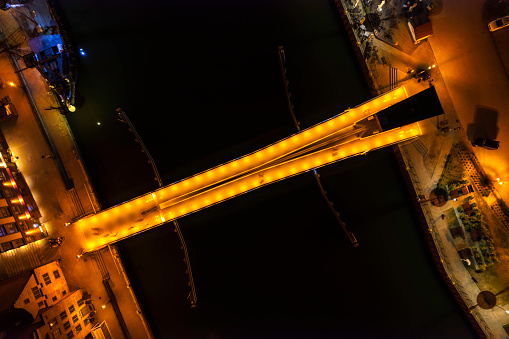 Gdańsk cityscape in the evening with a view to an railed footbridge located by the Motlawa river