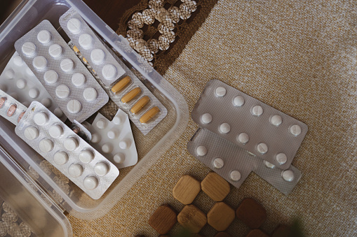 weekly pillbox with several capsules of daily medication.