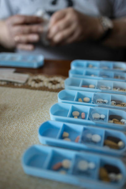 istock senior man is putting pills and capsules in a 7-day pill organizer 1425604446