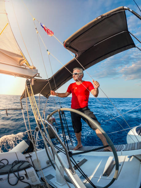 a man watches the environment on the autopilot boat. - yacht nautical vessel autopilot sailing imagens e fotografias de stock