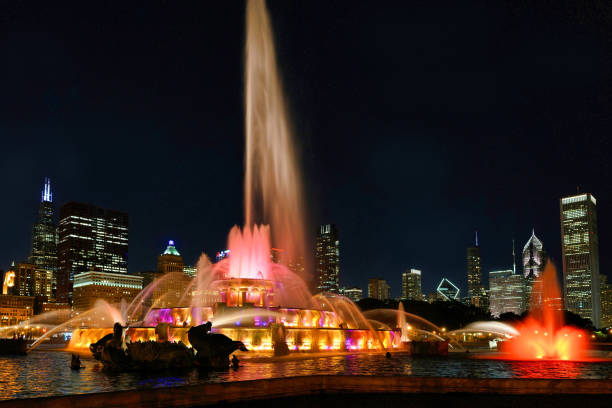 a histórica fonte de buckingham de chicago é iluminada à noite - chicago fountain skyline night - fotografias e filmes do acervo