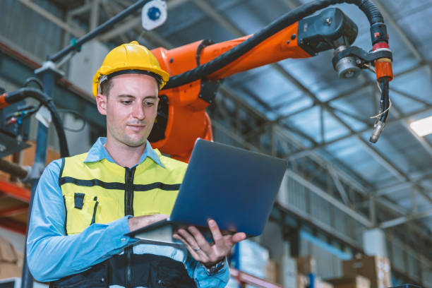 istock Caucasian engineer male worker working in metal factory with robot welding machine programmer controller and monitor. 1425613172
