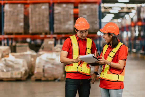istock warehouse worker working together happy smile work checking inventory stock order for shipping. 1425613396