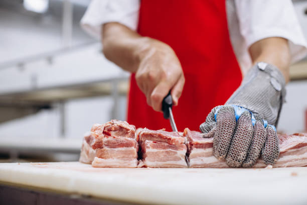 istock Man butcher at the freezer cutting meat 1425613407